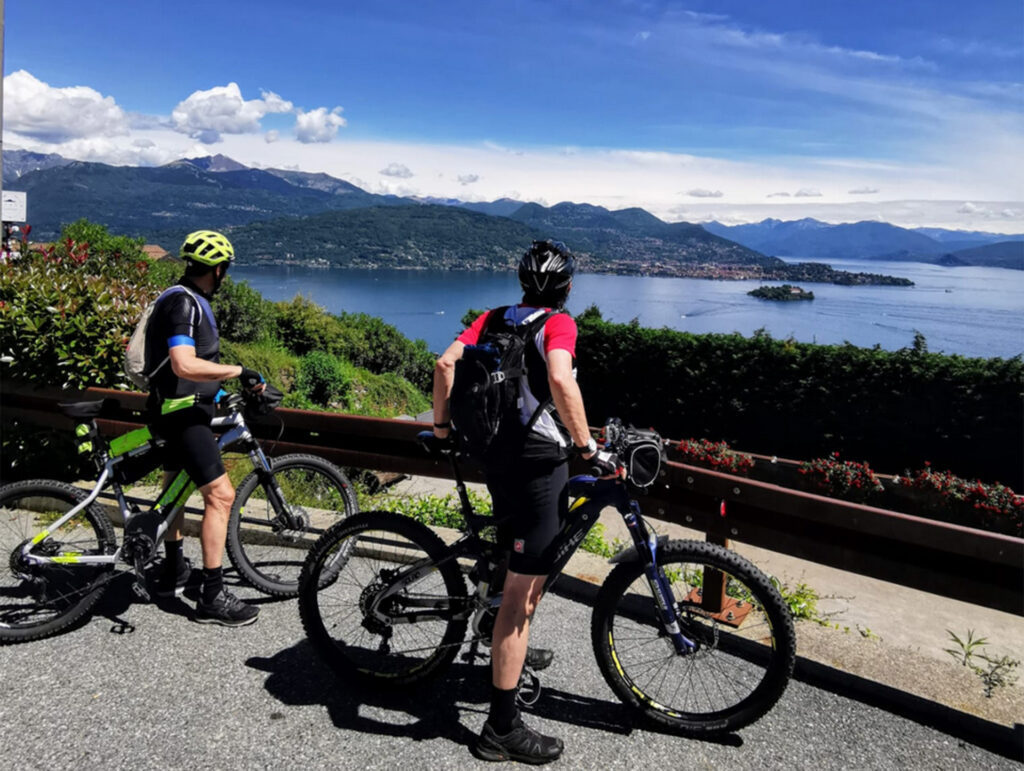2 cicloturisti in bicicletta che ammirano il lago