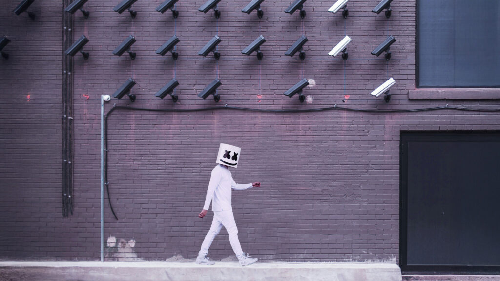 persona camuffata che cammina sotto tante telecamere metafora di privacy